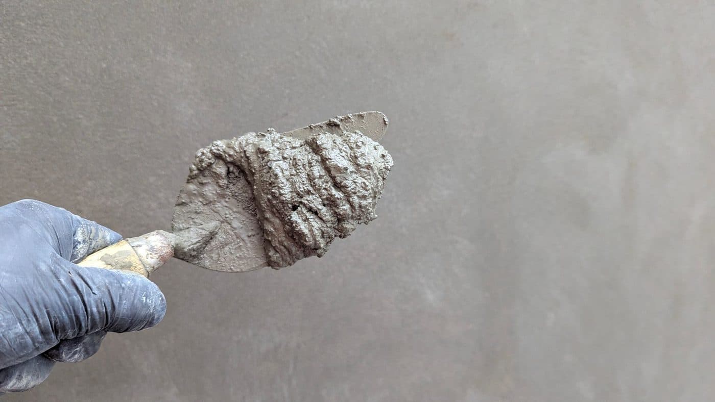 Artisan appliquant un enduit de lissage à la spatule sur un mur avant peinture