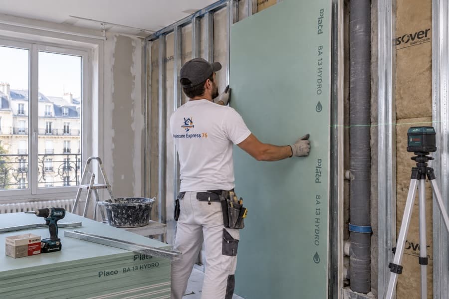 Artisan posant une plaque de placo